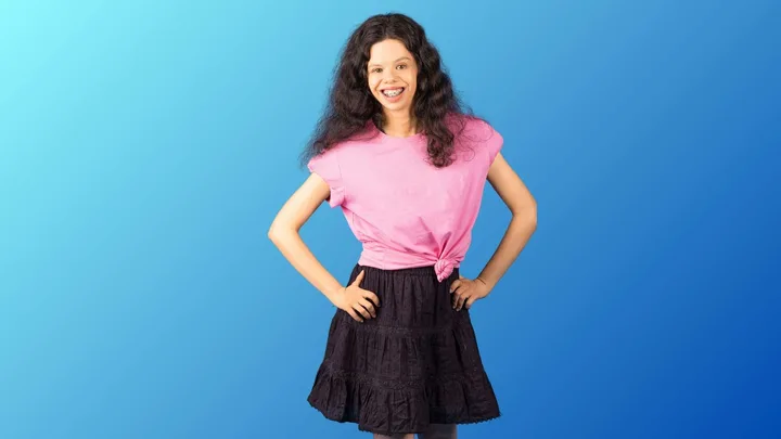 Mamie Macdonald in front of a blue and green gradient background
