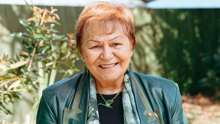 Dame Naida Glavish smiling in a green leather blazer