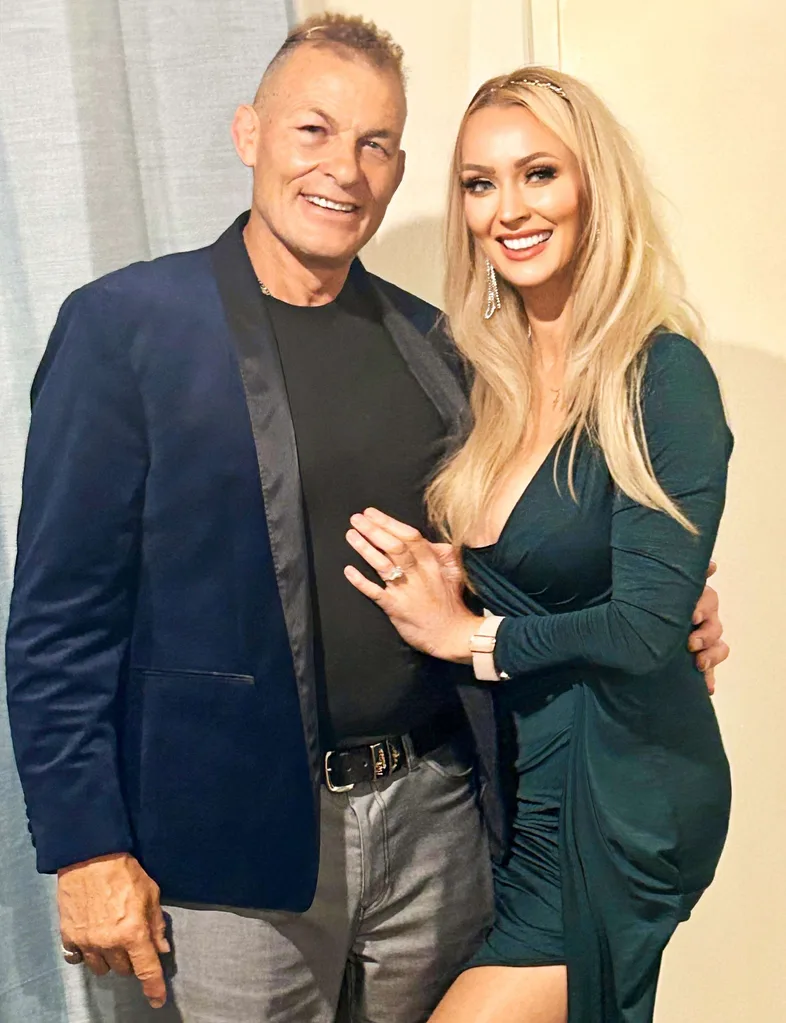 Jud with his fiancée in front of a curtain