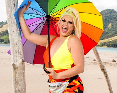 Spankie Jackzon with a rainbow umbrella on a beach for Celebrity Treasure Island