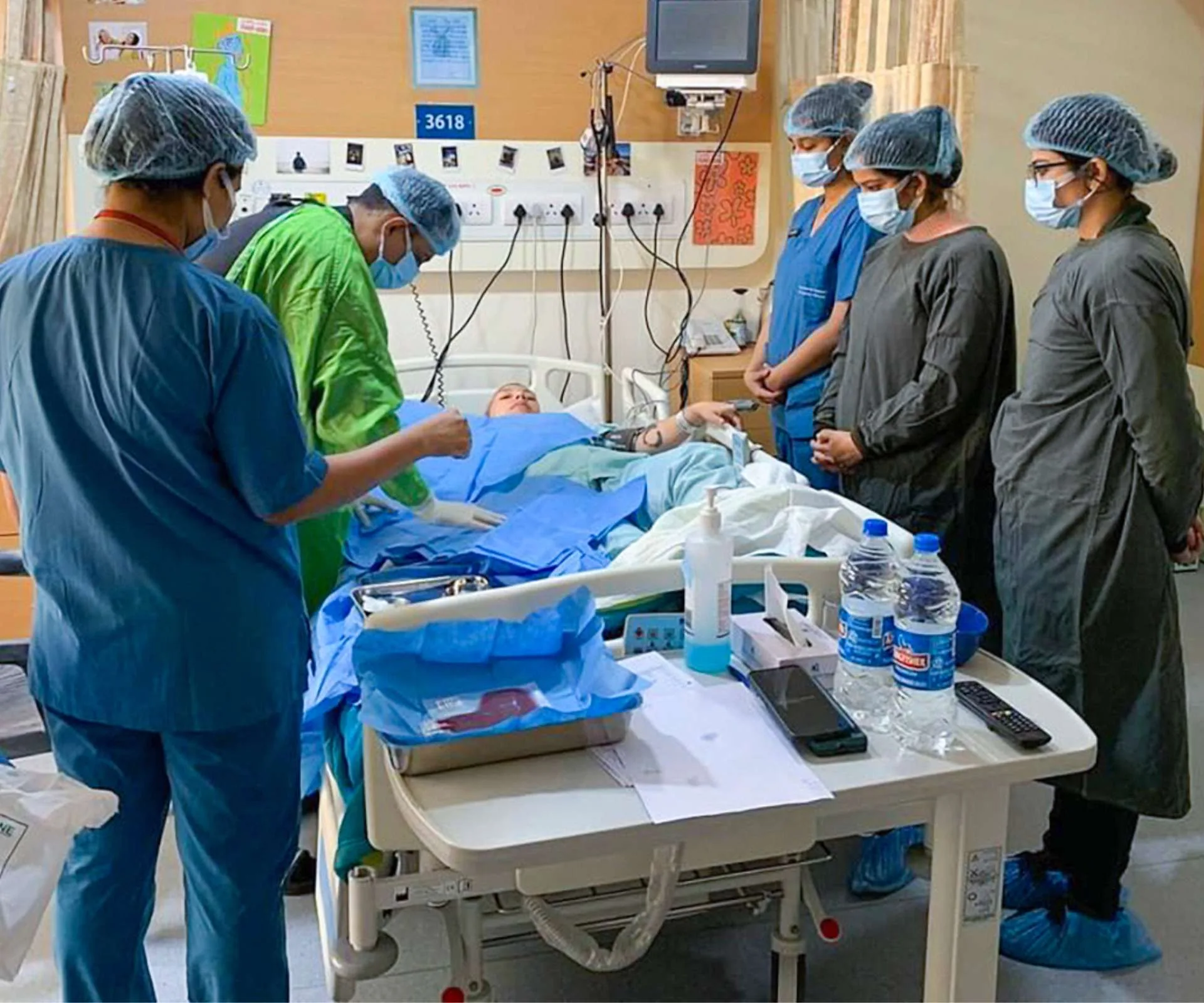 Six doctors standing around Zazi's hospital bed treating her multiple sclerosis