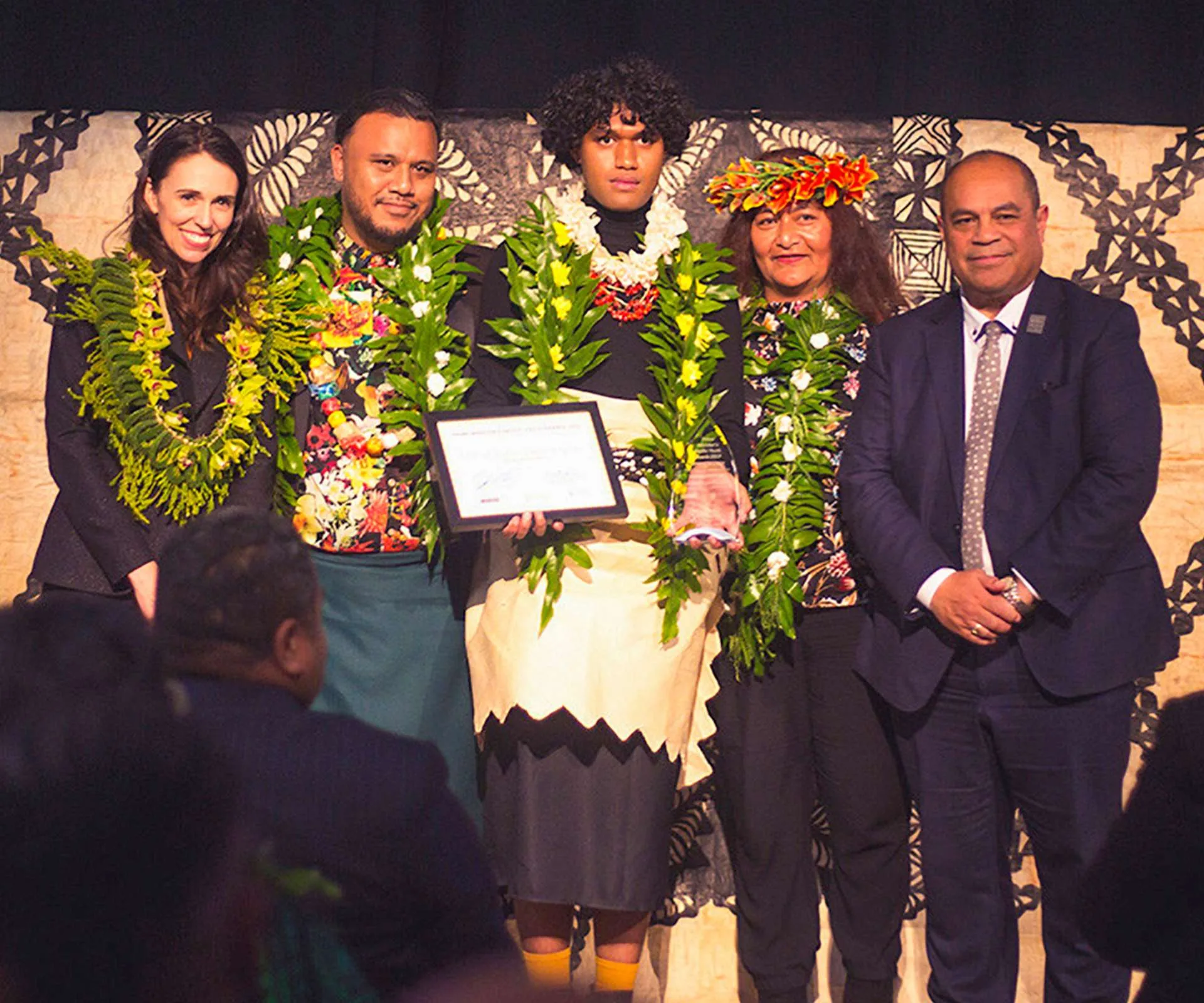 Manu Vaea receiving an award with family and the then-PM Jacinda Ardern