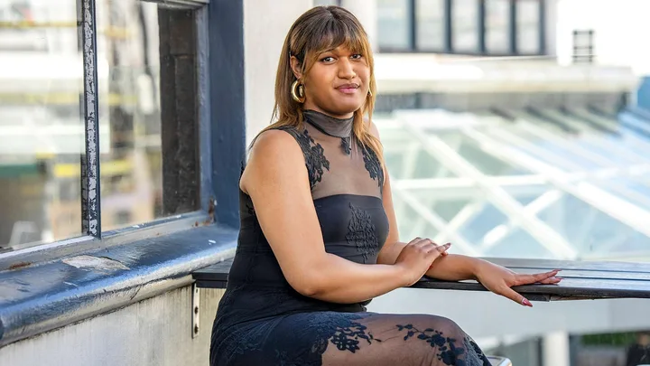 Manu Vaea in a black dress on a balcony