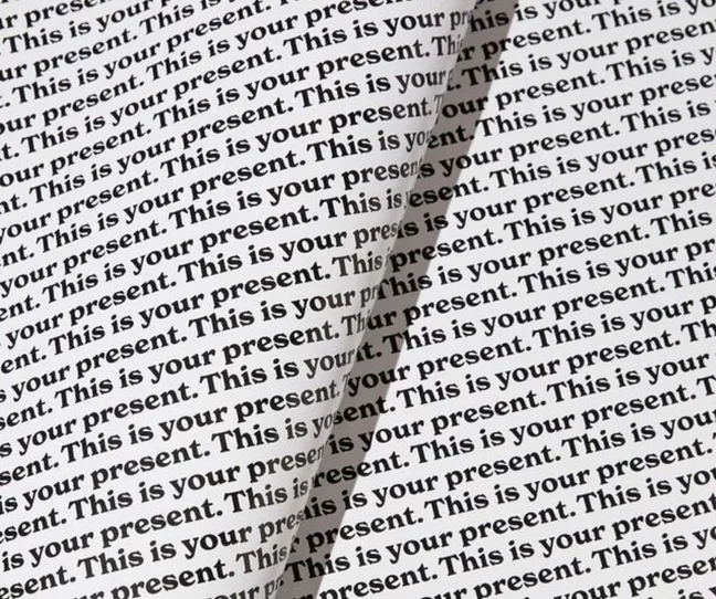 Wrapping paper with the words 'This is your present' printed repetitively across it