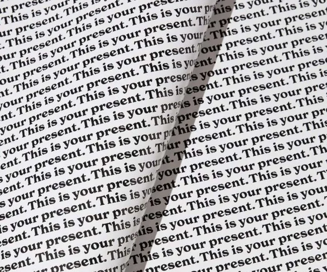 Wrapping paper with the words 'This is your present' printed repetitively across it