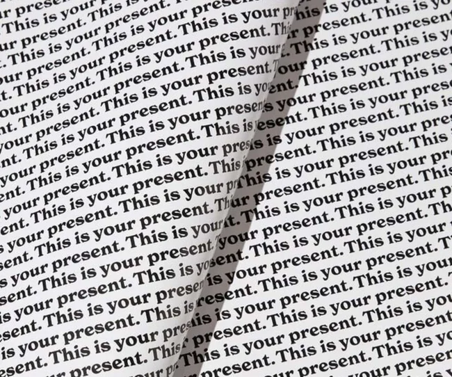 Wrapping paper with the words 'This is your present' printed repetitively across it