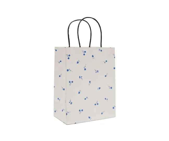 A white gift bag with small blue flowers scattered around