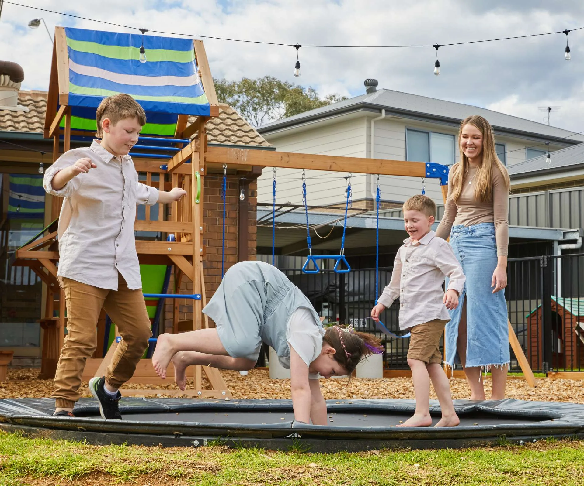 Renee watching her three kids with childhood dementia jumping on an in-ground trampoline
