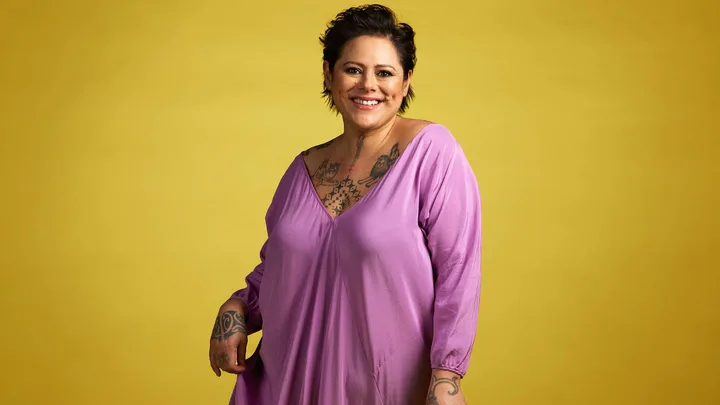 Anika Moa in front of a mustard backdrop