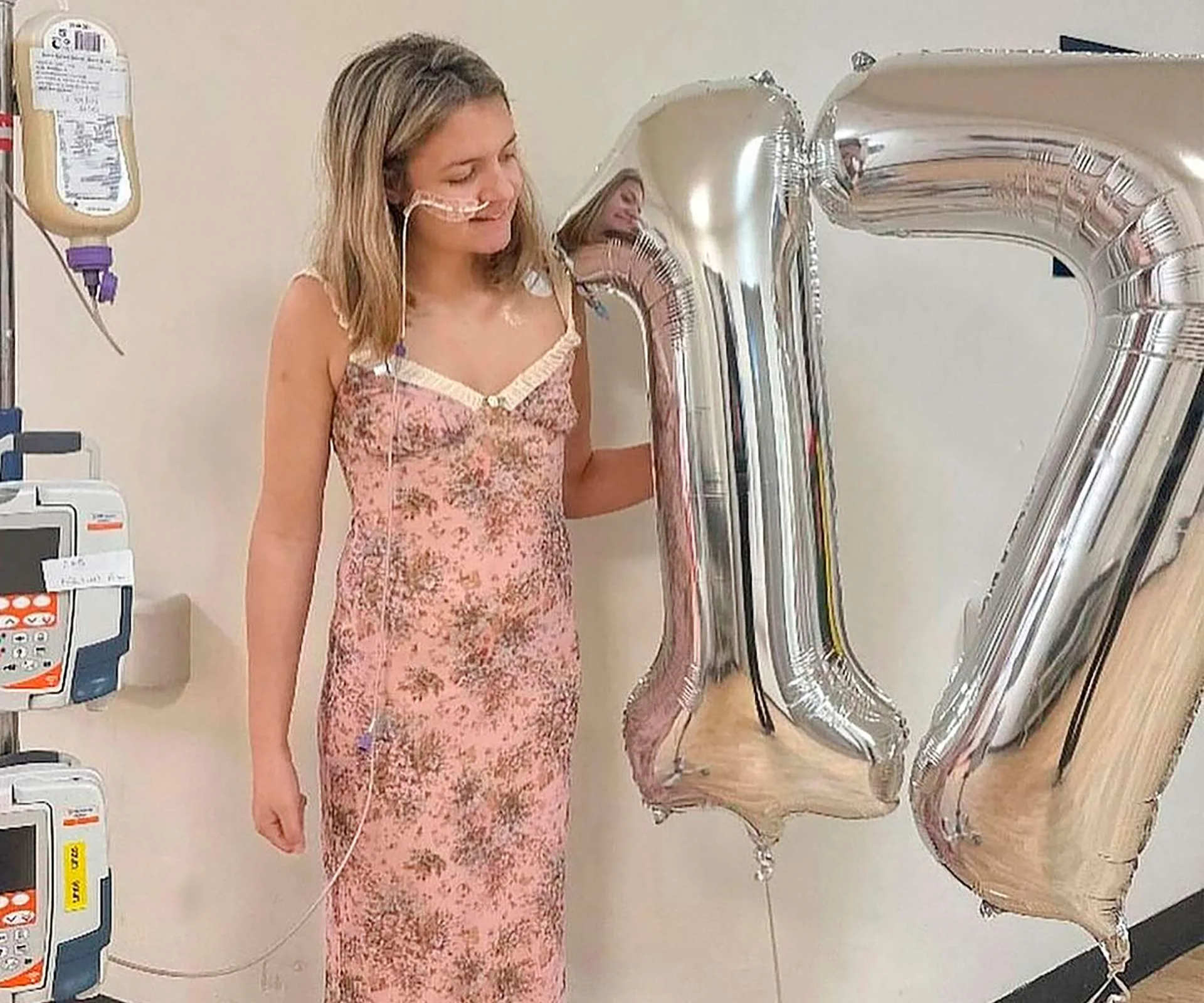 Eva Mitchell standing beside silver helium '17' balloons