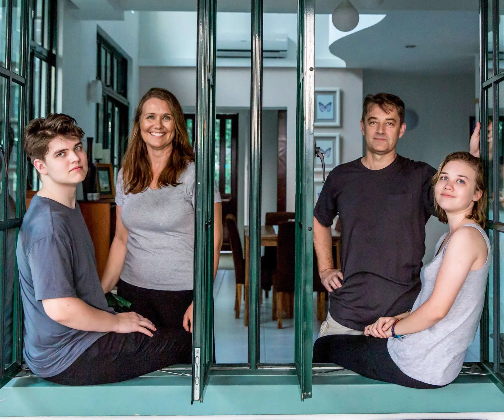 Kim Forrester with her teenage children sitting through a window ledge