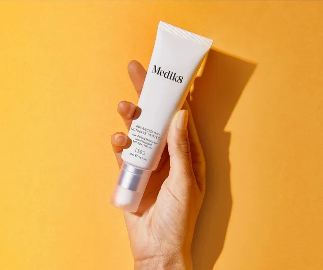 Medik8 sunscreen on orange background