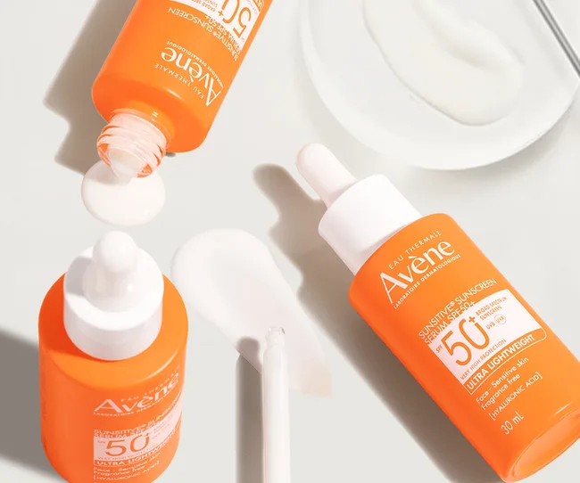 Avene sun serum in an orange bottle