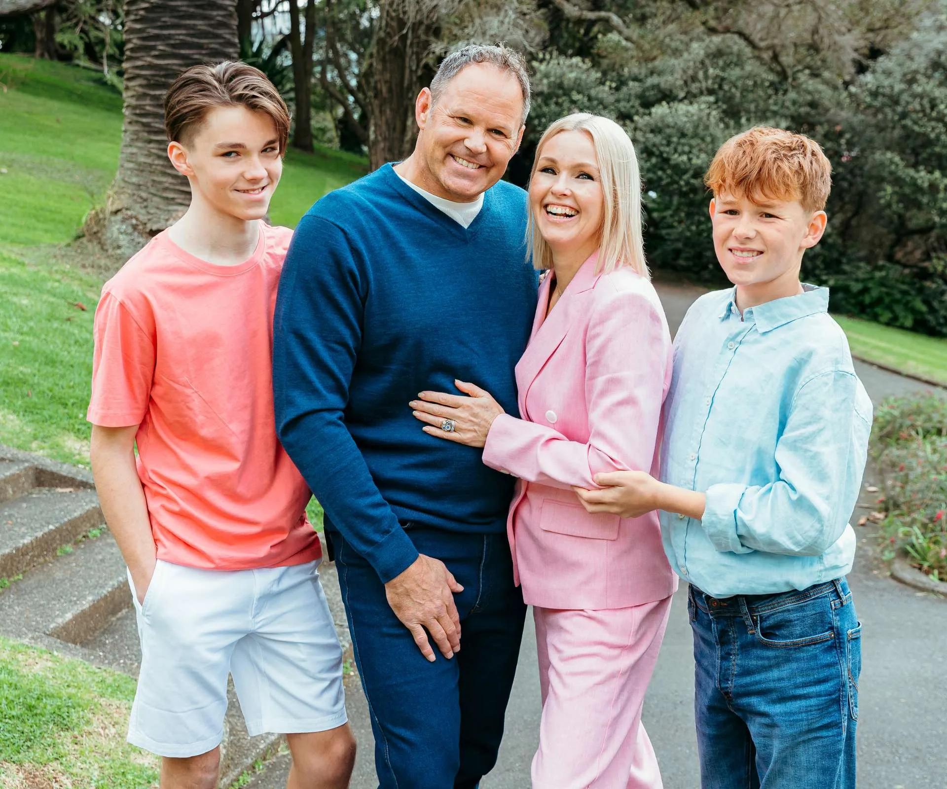 Josh Kronfeld standing with his wife and two sons in a park