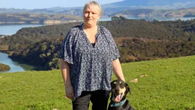 Stacey Scott standing on her farm with her dog