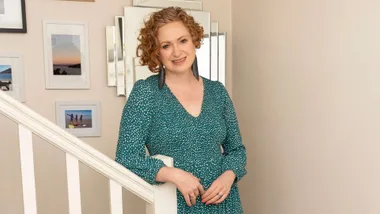 Susie Ferguson leaning on the banister of a staircase