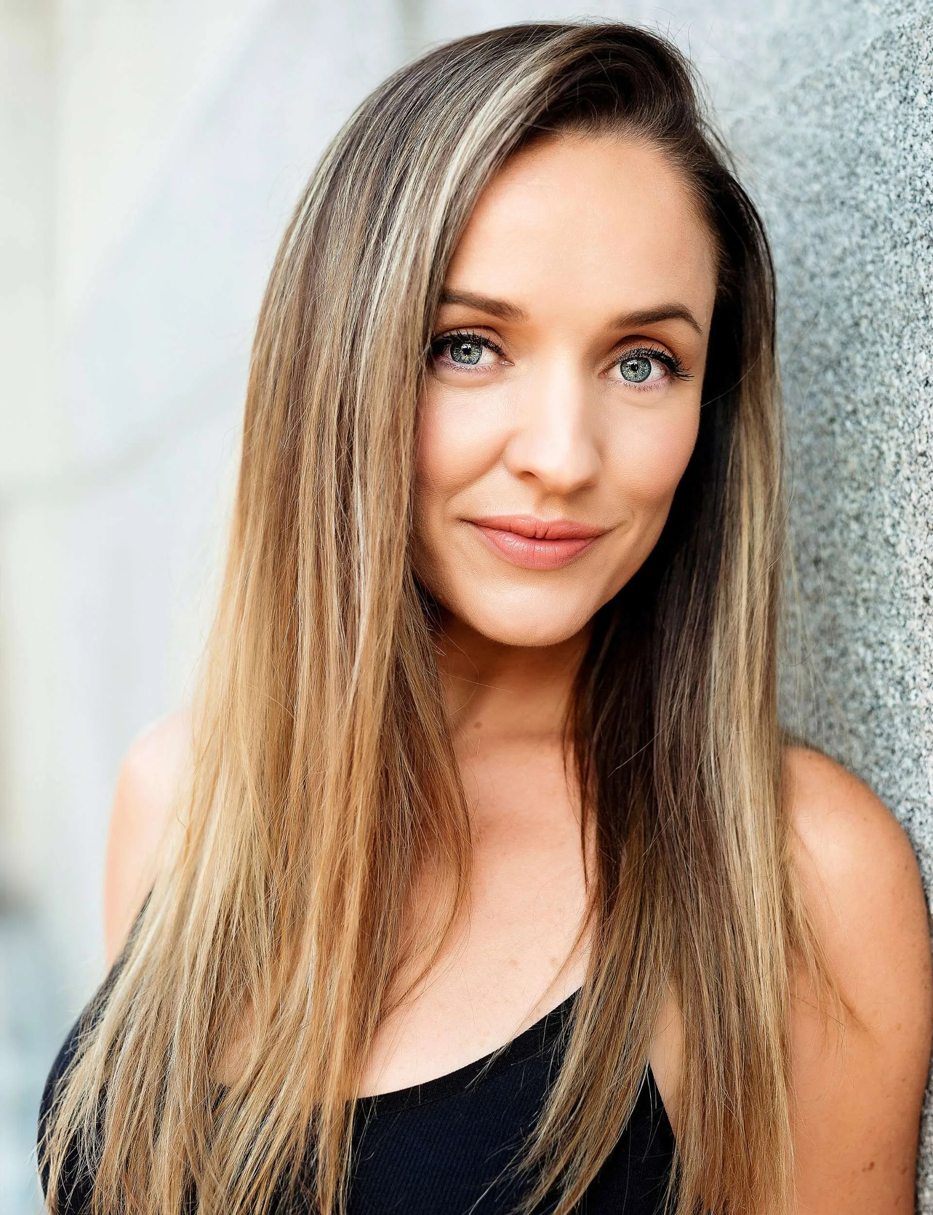 Katrina Devine smiling while leaning against a wall