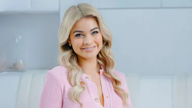Georgia smiling on a white couch
