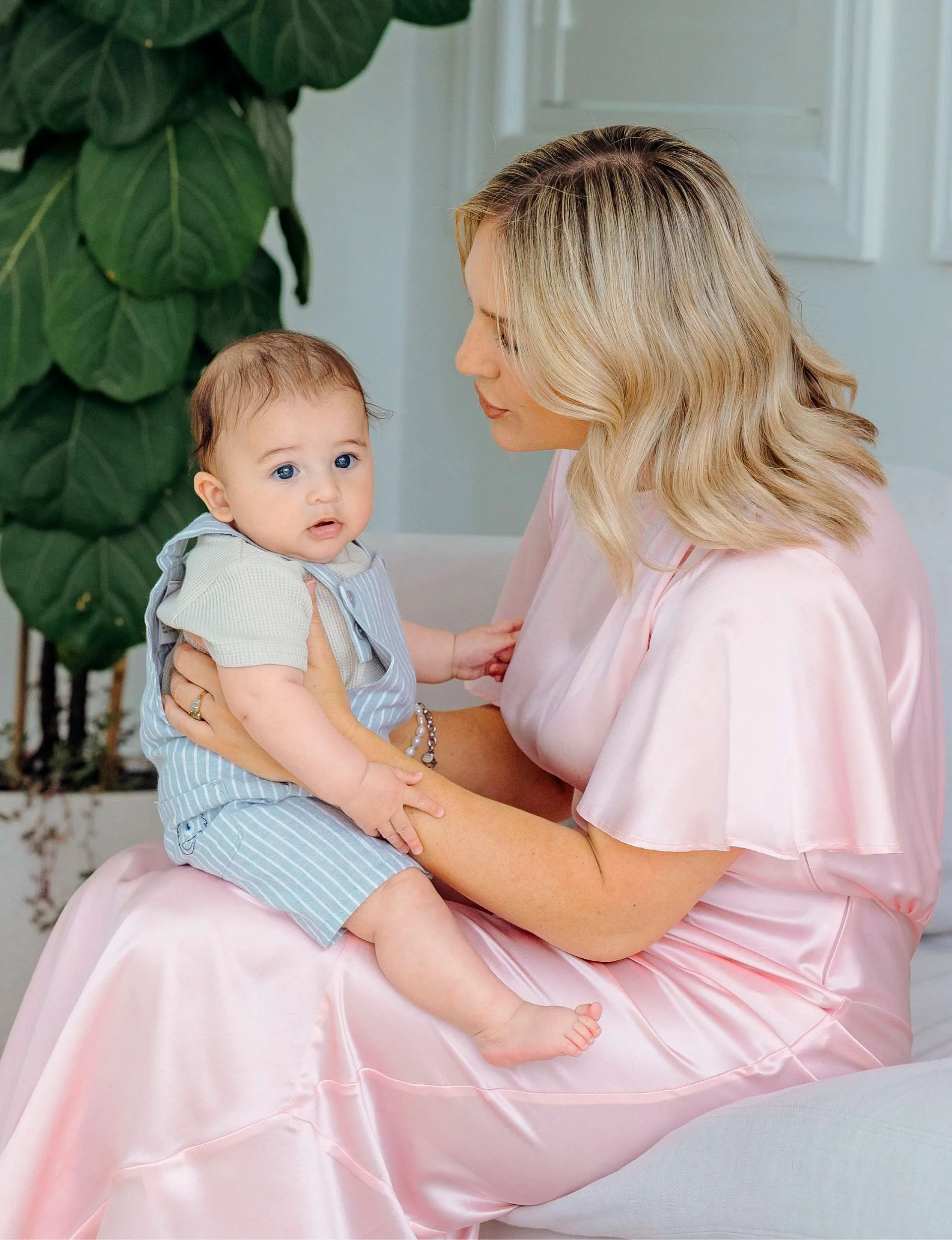 Hayley Holt bouncing baby Kingston on her knee
