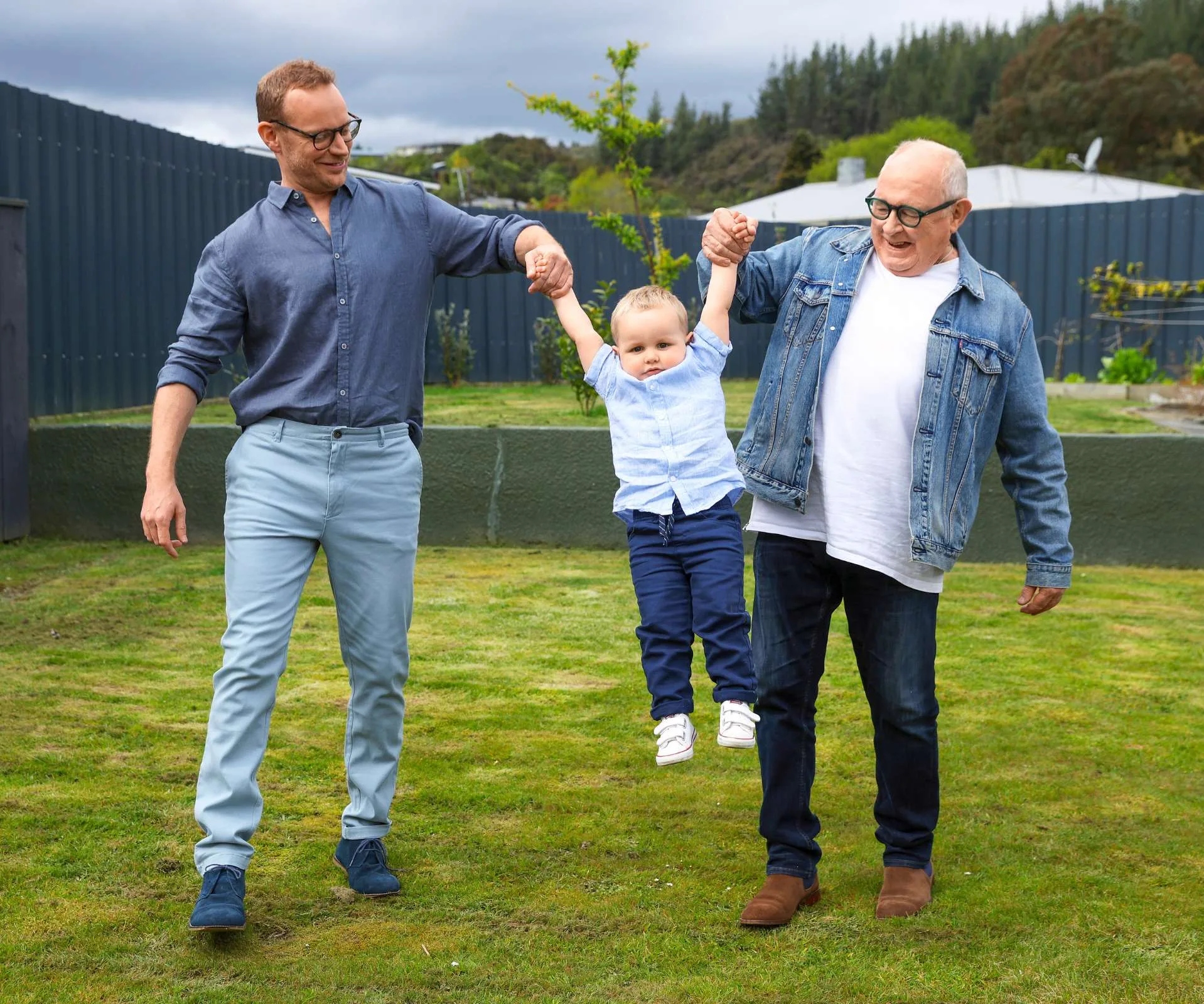 Kevin and Rory swinging toddler Benny between them