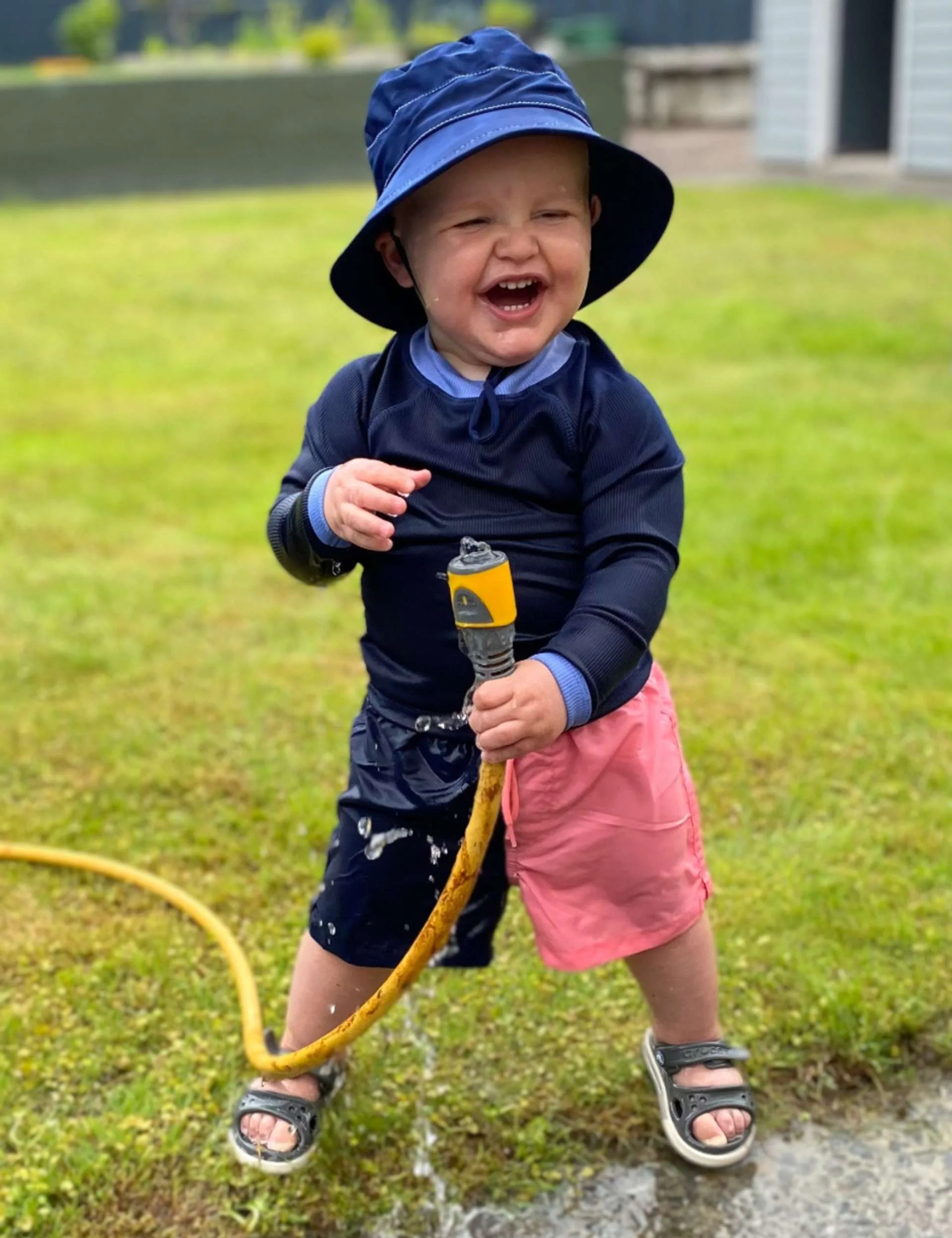 Benny soaking himself with a garden hose