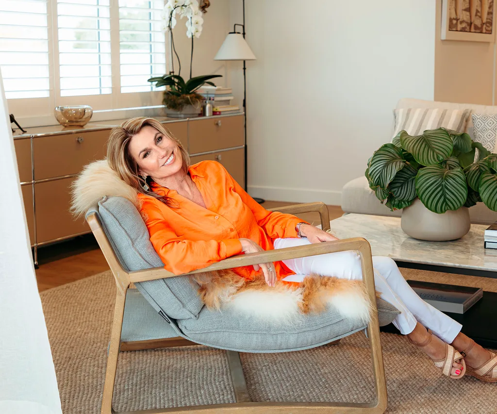 Jayne Kiely sitting in living room space, lounging back on chair