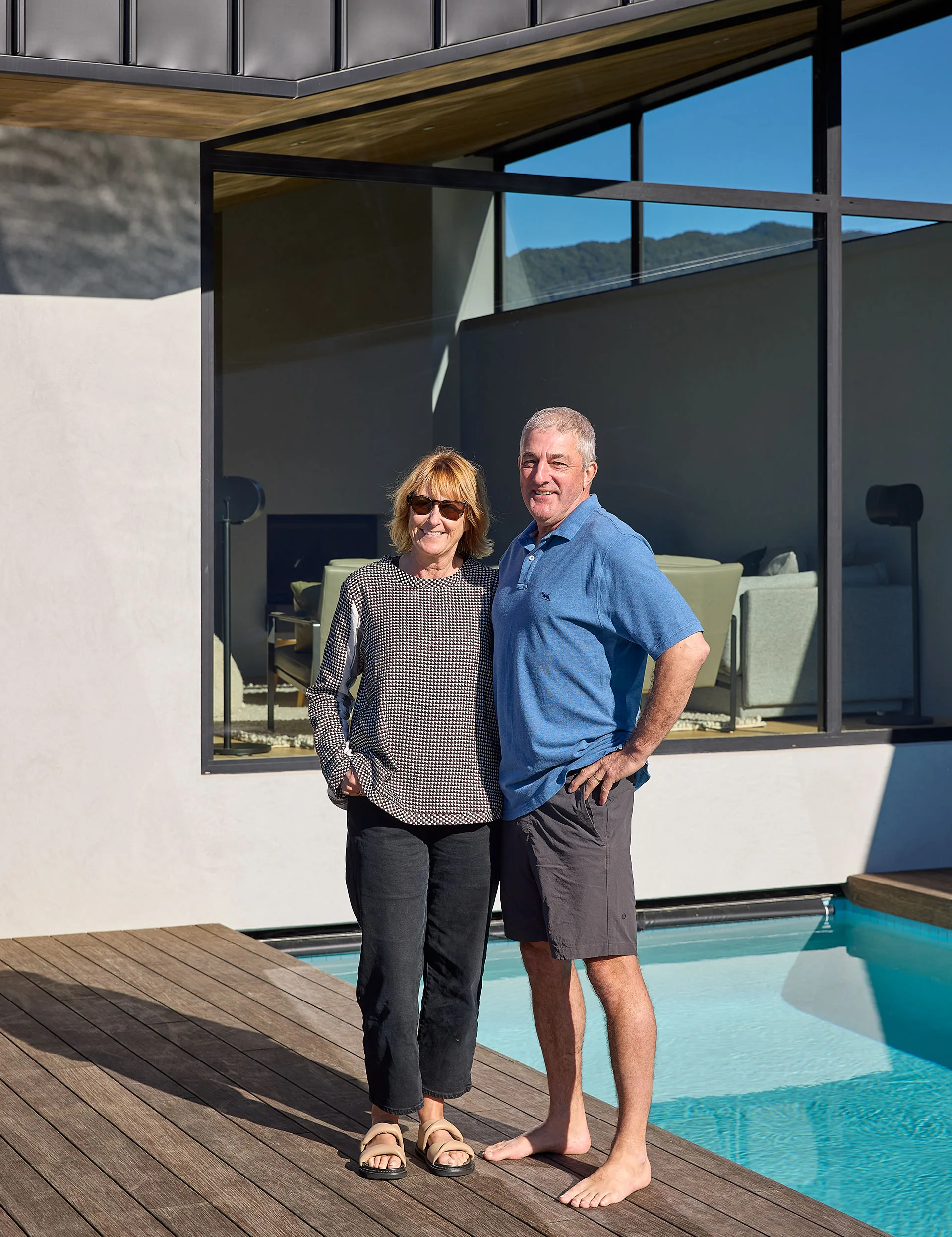 Homeowners Jane and Geoff Bews standing by their pool in Anakiwa