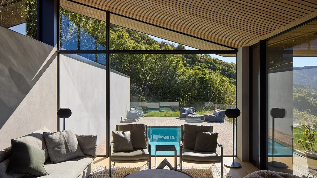 Two armchairs in front of Vantage floor-to-ceiling windows with a pool outside