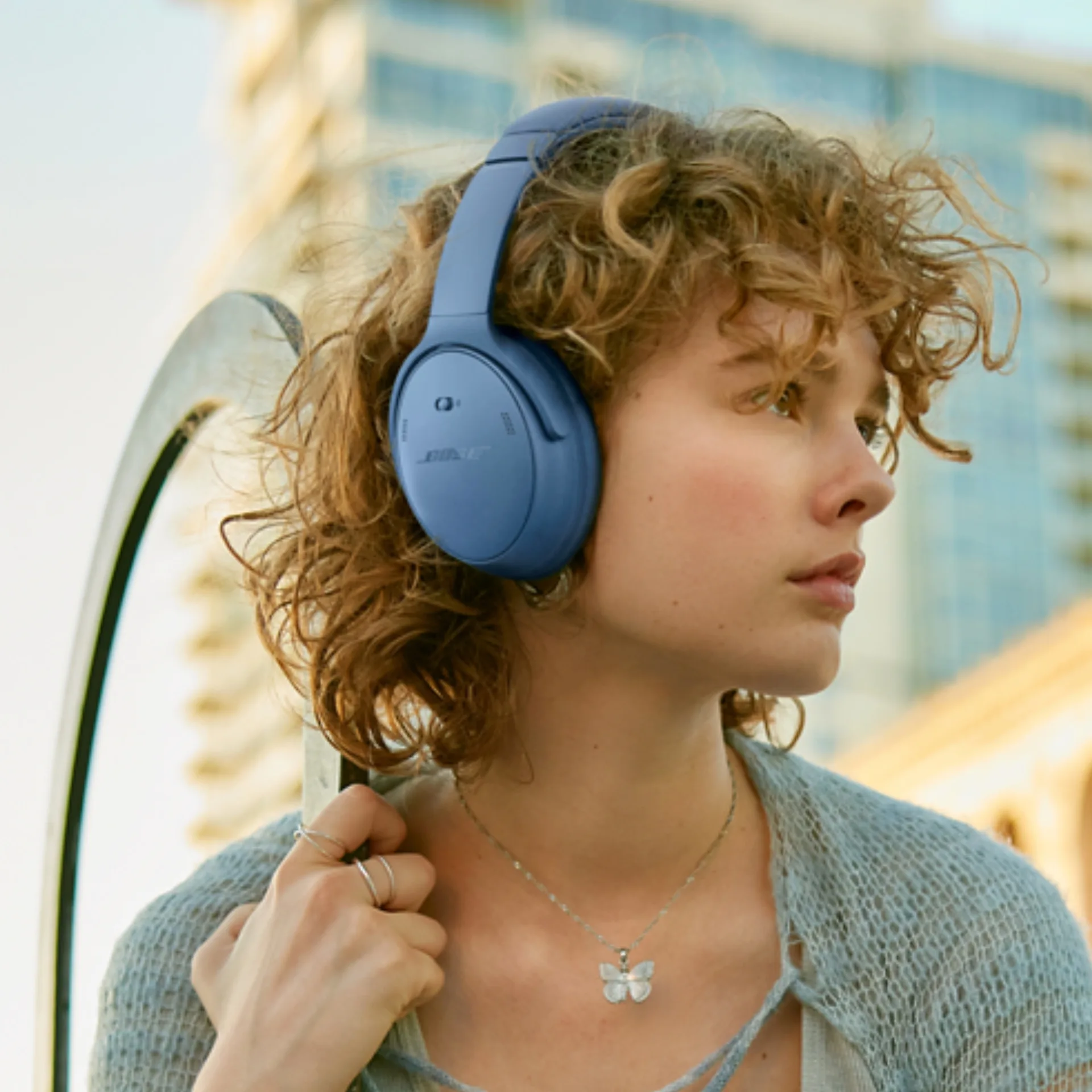 Woman wearing blue pair of Bose headphones