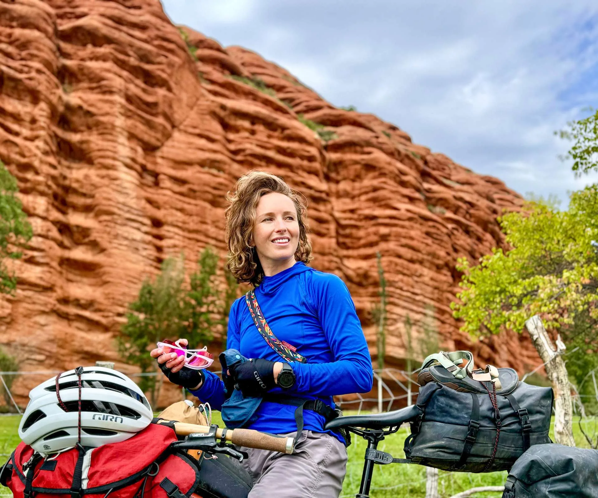 Isobel Ewing on her bike while bikepacking in front of a cliff