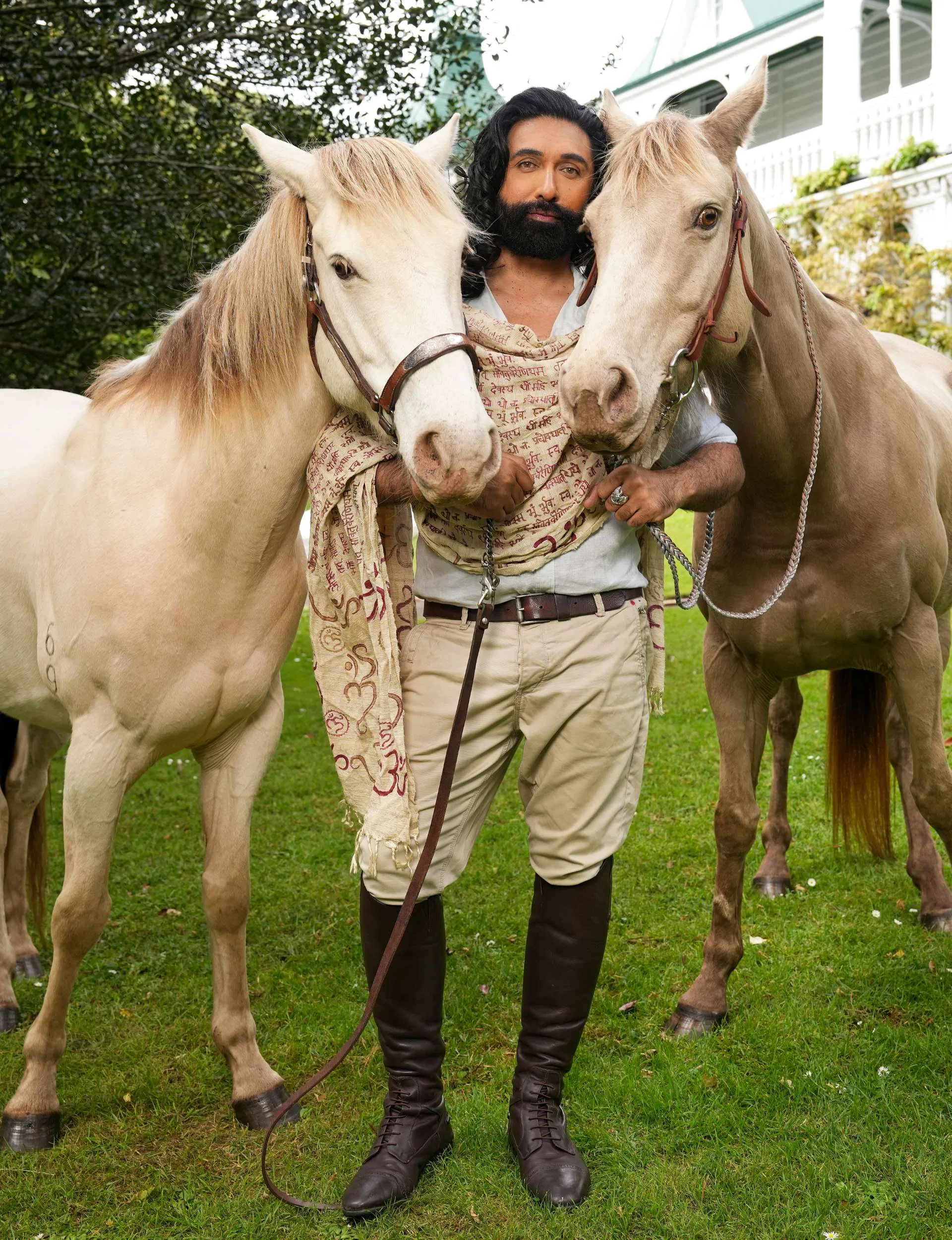 Colin Mathura-Jeffree holding the reins of two horses - one in each hand