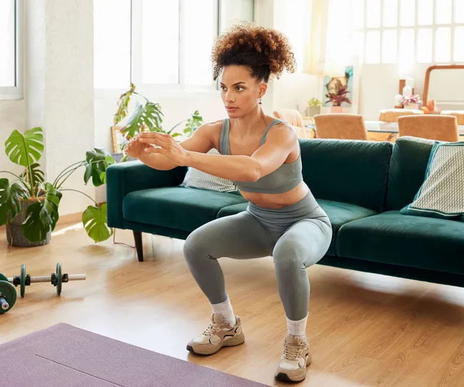A woman doing squats as part of her home workout