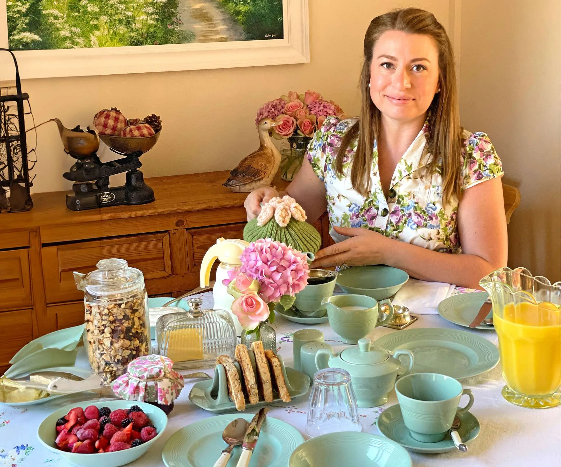 Trad wife Alena sitting a a table of fresh homemade food