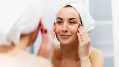 Girl with towel on head putting on skincare