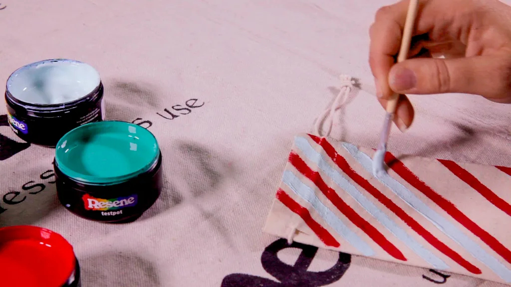 Step 2. Paint designs or numbers on the small calico drawstring bag