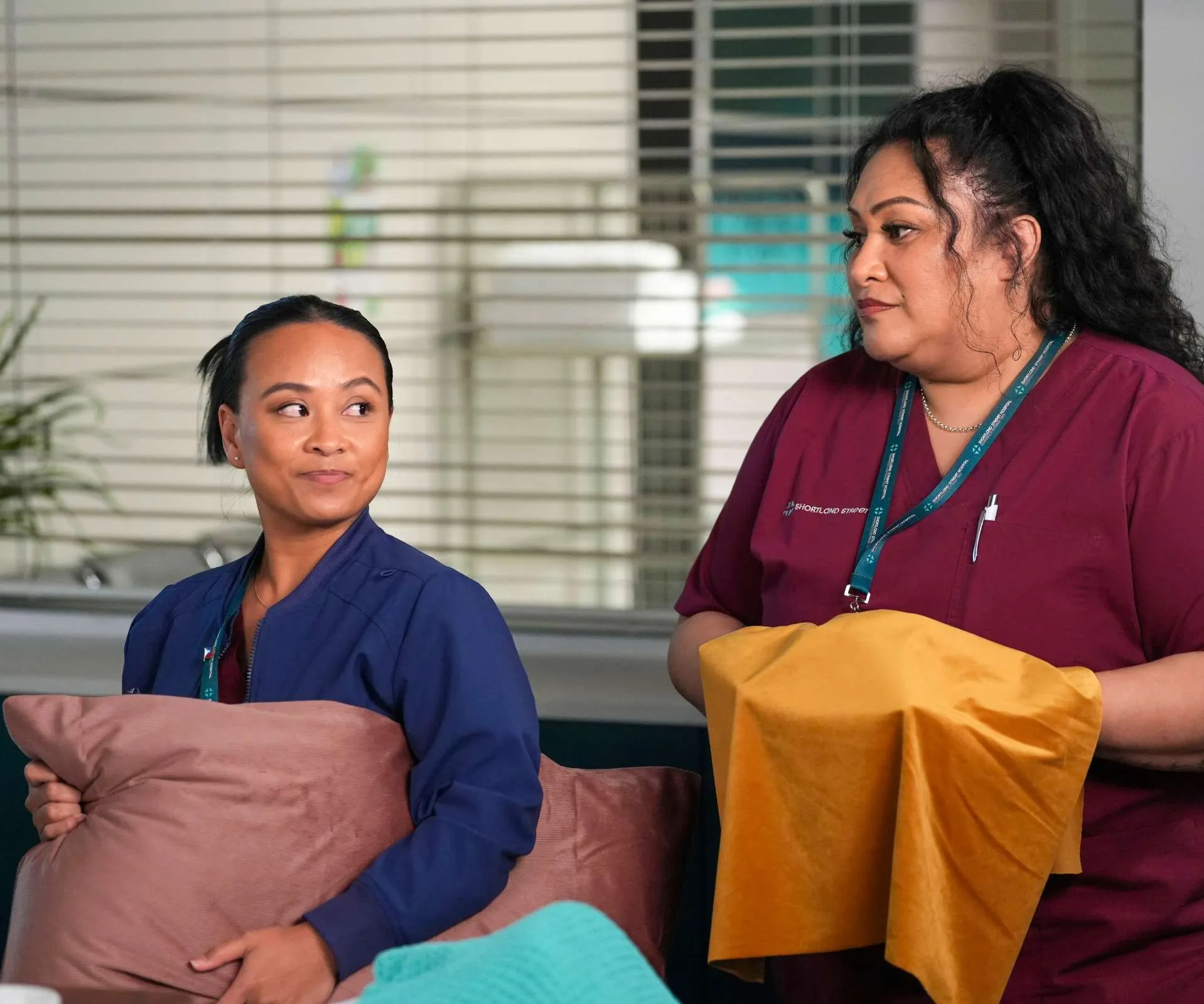 Marianne hiding her pregnancy behind a pillow on Shortland Street with co-star Bella