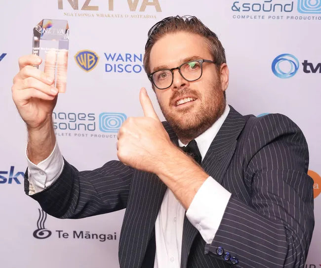 Guy Montgomery holding up his award at the 2024 NZ TV Awards