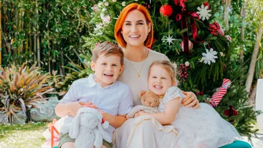 Samantha Hayes sitting in front of a Christmas tree with her kids