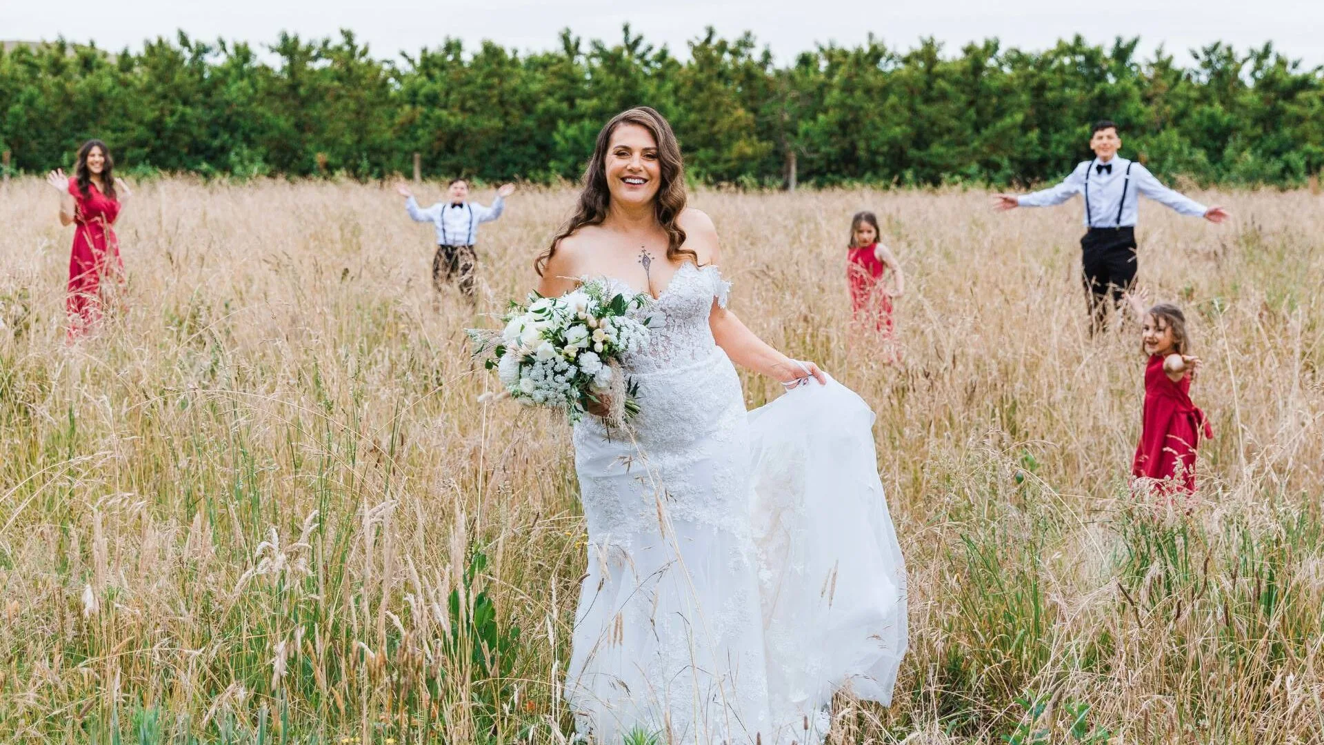 K’Lee in some long grass with her kids on her wedding day