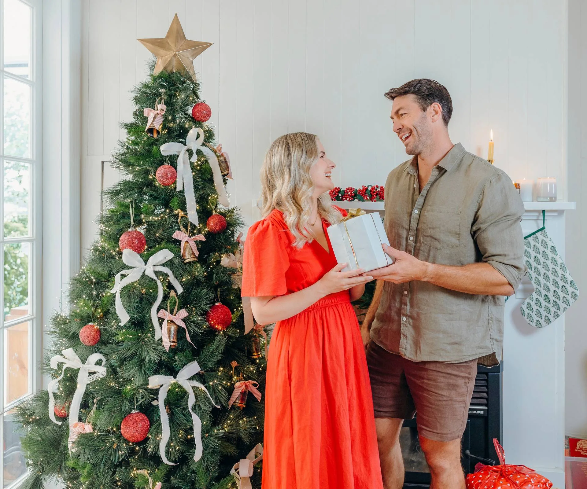 Art and Matilda exchanging gifts in front of their Christmas tree