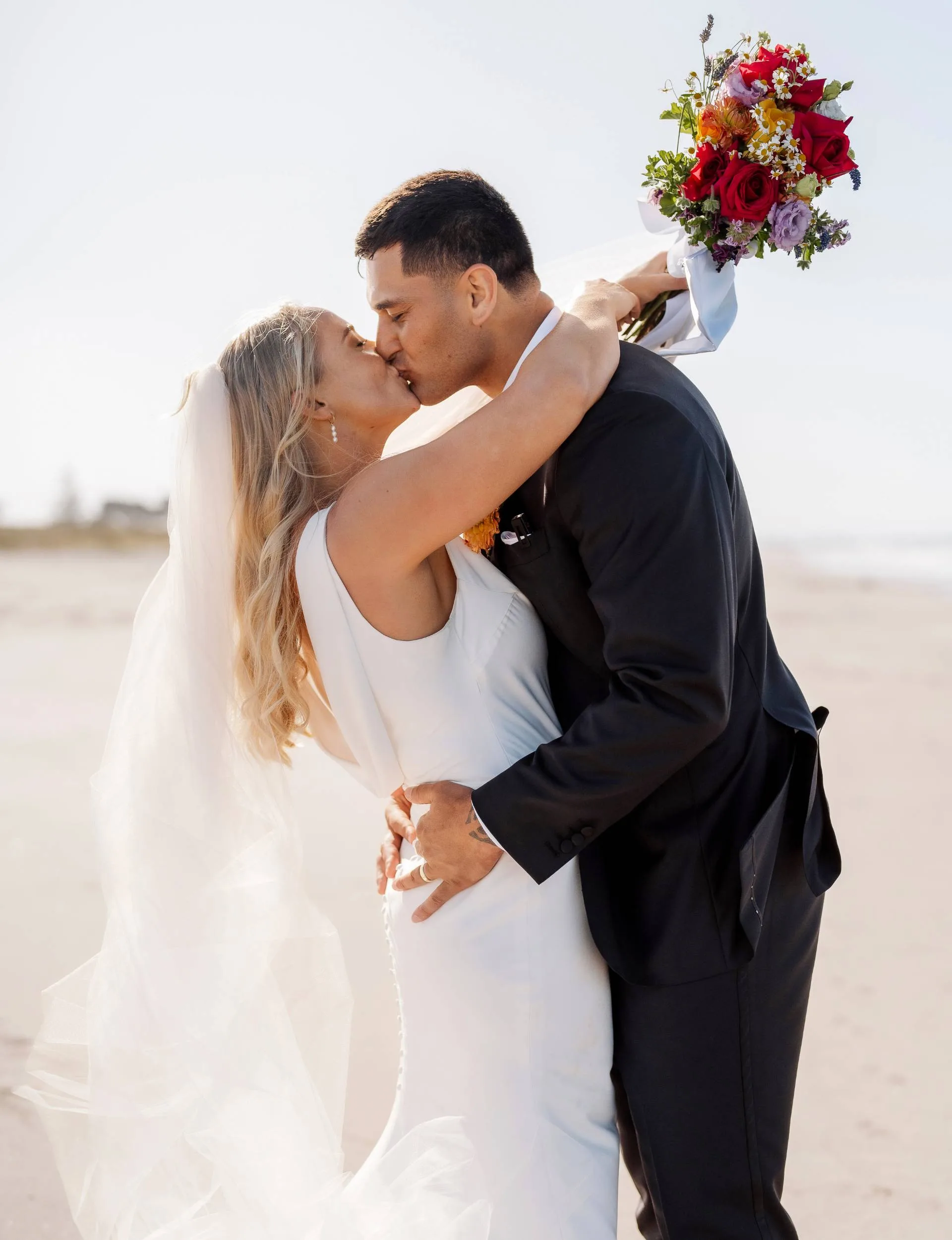 Grace Steinmetz and Rameka Poihipi kissing on a beach
