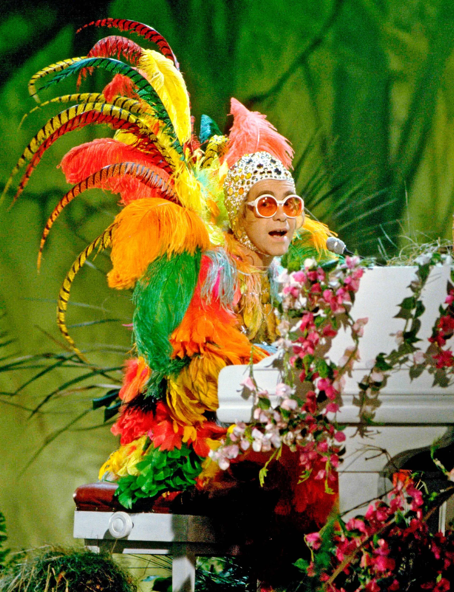 Elton performing in a vibrant bird-like costume