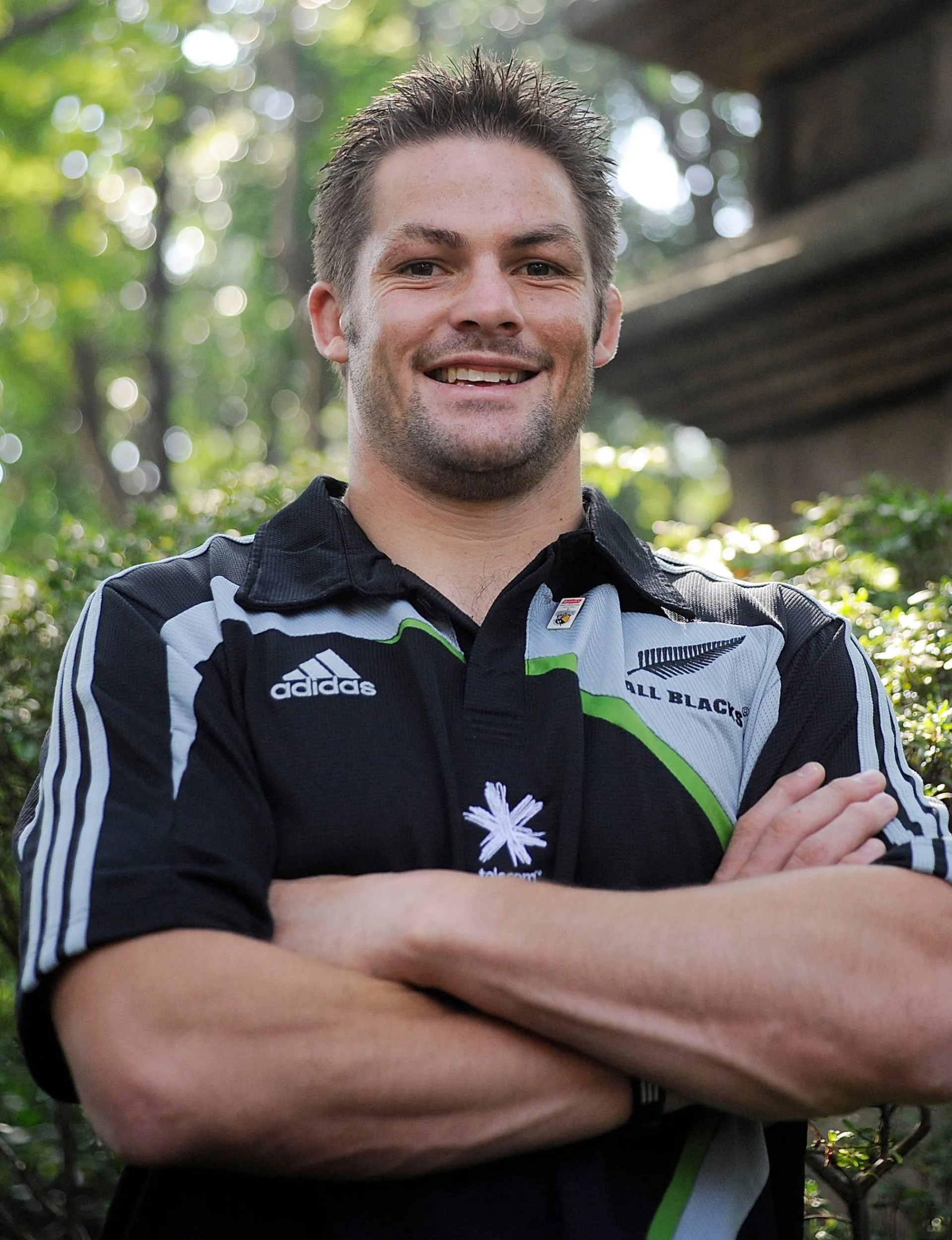 Richie McCaw crossing his arms and smiling