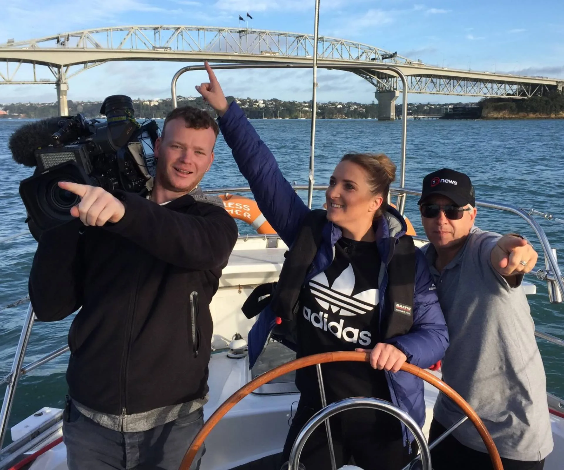 Brodie and her news crew on a boat, all pointing in different directions