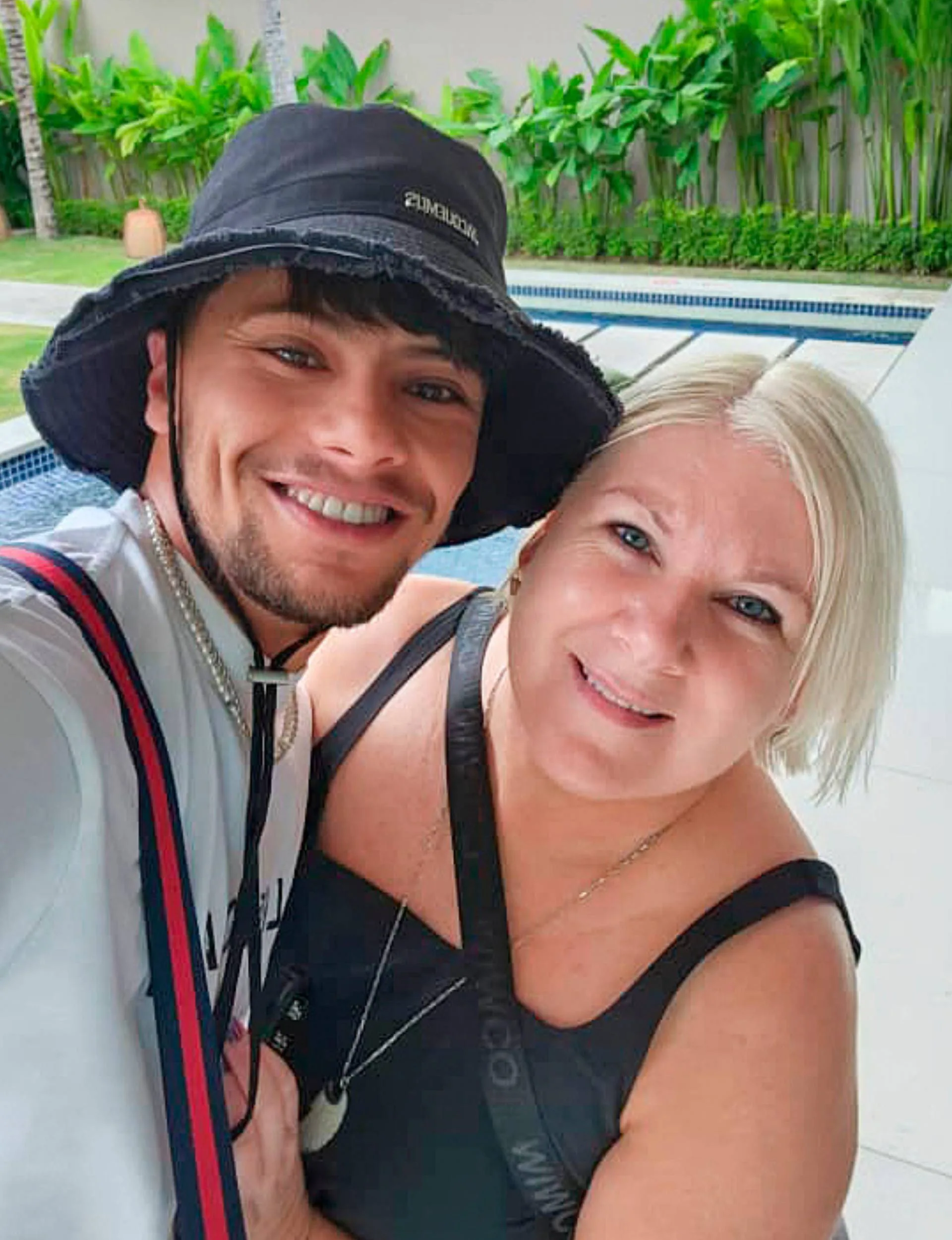 A selfie of the couple in front of a pool