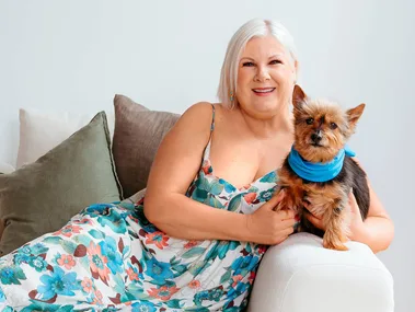 Jay-Jay Feeney sitting on a couch with her puppy