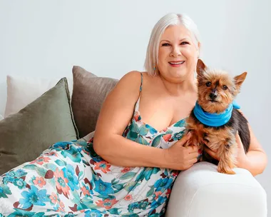 Jay-Jay Feeney sitting on a couch with her puppy