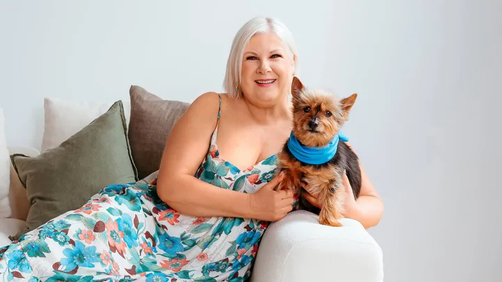 Jay-Jay Feeney sitting on a couch with her puppy