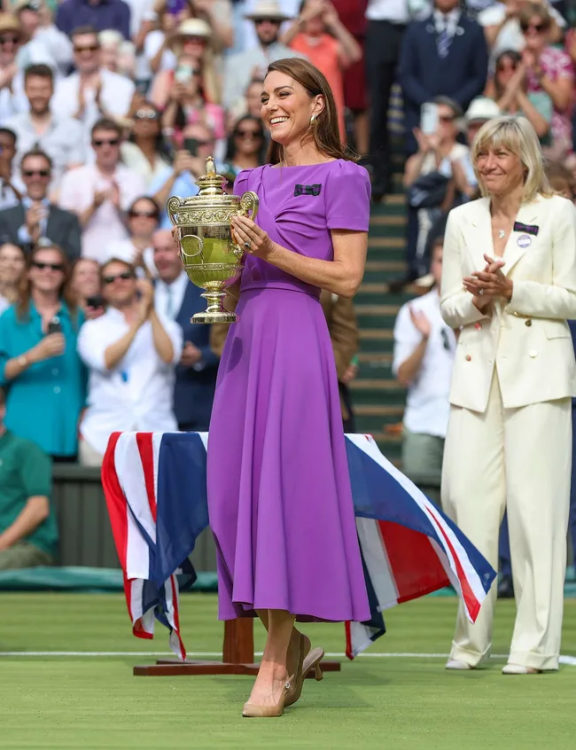 Kate Middleton holding trophy and wearing a purple dress