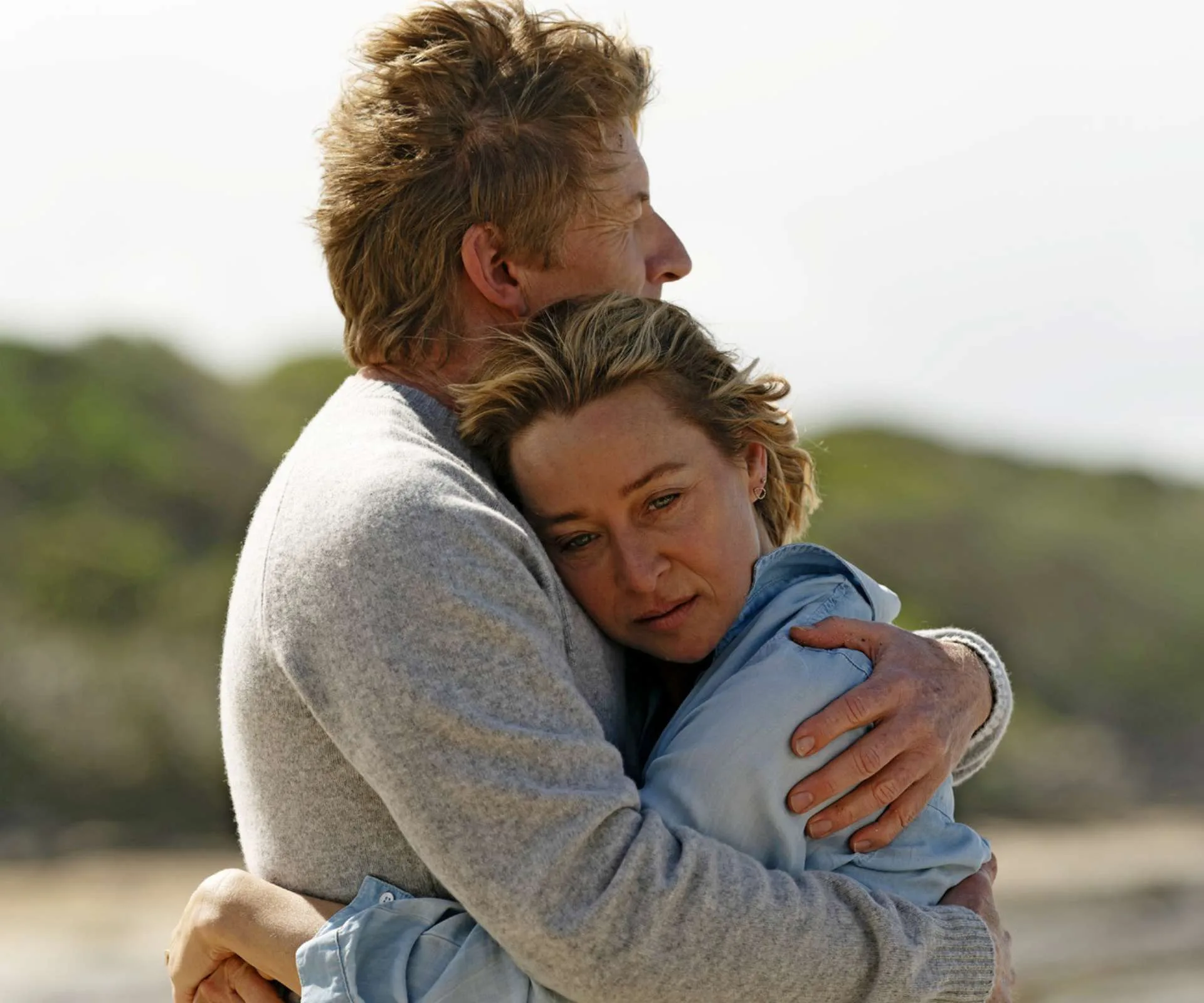 Man & woman embracing in hug on a beach